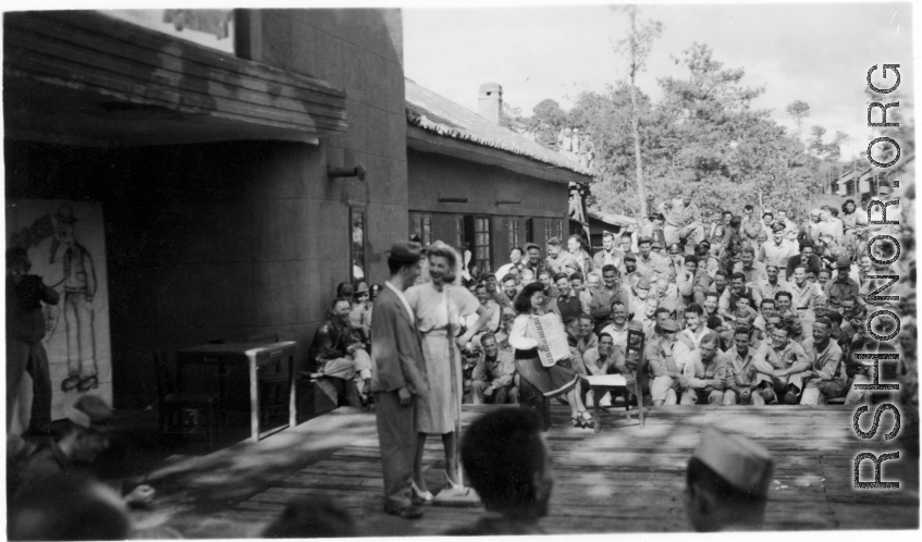 Celebrities (including Ann Sheridan in this shot) perform on an outdoor stage set up at the "Last Resort" at Yangkai, Yunnan province, during WWII. Notice both Americans and Chinese in the audience for this USO event.