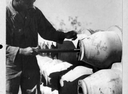 African-American serviceman putting the M-14 in the igniter of a M-76 500-pound incendiary bomb in China during WWII.