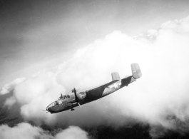 B-25 Mitchell bomber #448 in flight in the CBI, in the area of southern China, Indochina, or Burma.