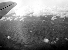 A rough karst mountain landscape as seen from a B-25 Mitchell, in SW China, or Indochina, or the China-Burma border area.  
