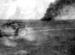 An American aircraft burns at a base in China during WWII.