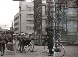 A city gate in Kunming city, Yunnan province, China, during WWII, with a Nationalist soldier riding a rickshaw. 