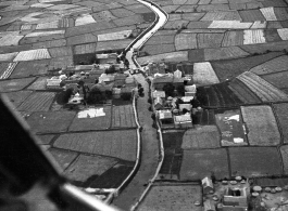 A tidy village near Kunming, as seen from the air, during WWII, with a canal passing through the village.