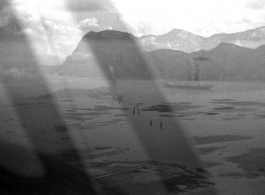 View over Dianchi Lake (滇池) outside of Kunming, China, during WWII. Small boats with sails move in a line on the water surface. 