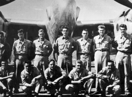 Men from the 21st Photographic Reconnaissance Squadron pose for a group shot in front of an F-5 (a variant of the P-38).
