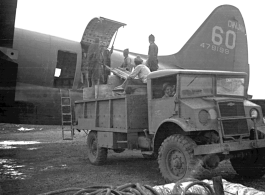 A C-46 transport plane (tail number #478199) being unloaded of fuel barrels by Chinese laborers at the air base at Luliang. During WWII.