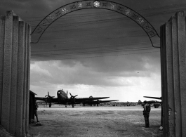 Guarded gates of the Nationalist Kunming Air Force Officer Training School during WWII, with C-46 transports, and a fuel trailer (on the far right).