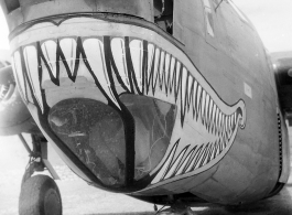 A shark-mouth B-24, the mouth having a unique curl at the back, in a revetment in SW China, likely Sichuan, during WWII. This is a later model B-24 as indicated by the nose turret with two .50 cal machine  guns.