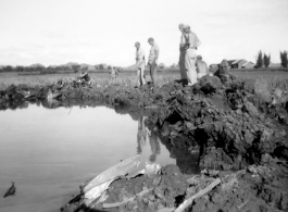 GIs look over devastating crash site of an American aircraft--the bent .50 cal machine gun in one image indicates it is American, and the gun mounting is like that of the nose gun of some B-25 Mitchells.  In this image set, the intensity by which people are searching the crash site, and the solemn nature of it all, makes one wonder if they are not looking for human remains.