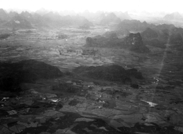 Aerial view of karst mountains and fields in either SW China or French Indochina, in the CBI, during WWII.