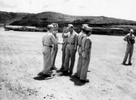 Major Gen. Charles B. Stone salutes during an award ceremony during a visit to Yangkai on the August 29, 1945. A photographer stands on the far right.  Yangkai, APO 212, during WWII.