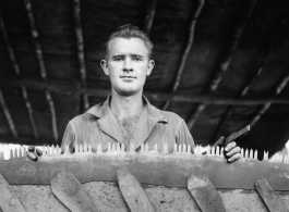Engineer of the 797th Engineer Forestry Company in Burma, with saw in jig, being sharpened.  During WWII.