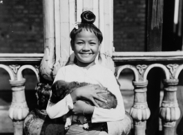 Local people in Burma near the 797th Engineer Forestry Company--A happy girl holding a  puppy; a boy and woman. In Burma.  During WWII.