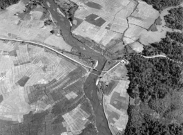 Aerial view of Burma Road bridge under construction amid rice paddies.  During WWII.