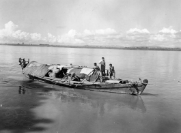 People pole a boat in Burma.  Local people in Burma near the 797th Engineer Forestry Company.  During WWII.