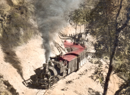 A Darjeeling Himalayan Railway (DHR) B Class 2 ft. saddle tank steam locomotive and train cars climbing the mountain. Hand-tinted image.