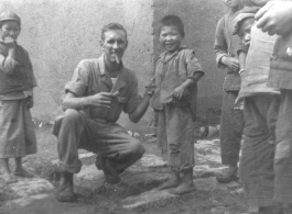 Walter L. Wegner, cigar in mouth, with children in SW China during WWII.