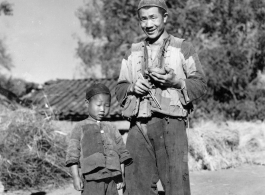 Chinese boy and man at Chanyi (Zhanyi), during WWII, at mealtime.