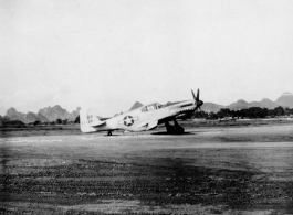 A P-51 fighter at a base in China during WWII. Tail number #271 37124. Although David Axelrod spent at least part of his time at Luliang, the karst formations in the background do not resemble the mountains of Luliang, and this is morel likely a base in Guangxi, such as Liuzhou, etc.