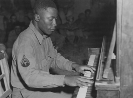 African-American musician playing piano for other GIs in the CBI during WWII.