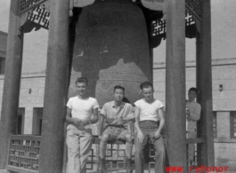 GIs of SACO and a Chinese soldier sit in front of a large cast bell, next to the Lanzhou City Hospital (兰州市立医院) in Gansu province, China, during WWII.