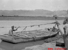 GI observes boat carrying produce on river in northern China, a Muslim man at the helm. This is most probably the Yellow River. During WWII.