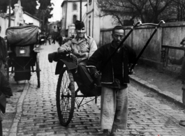 An American serviceman in the CBI riding a rickshaw pulled by a Chinese man.  From the collection of Wozniak, combat photographer for the 491st Bomb Squadron, in the CBI.