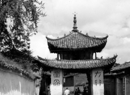 Local people and a whitewashed gate in Luliang, Yunnan province, China. During WWII.