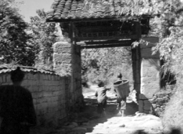 Villagers going through a narrow village gate in Yunnan province, China.