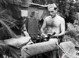 During WWII in China, an American GI operates a portable radio from the back of a vehicle in near Guilin, Guangxi province.