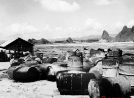 "Empty gas drums burned during raid." Karst hills in the background hit that this is likely a US base in Guangxi province, China, either at Liuzhou or Guilin.