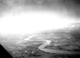 An image of a river and the ground as seen from a B-25 Mitchell, in SW China, or Indochina, or the China-Burma border area.
