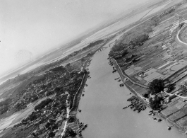 A fly-by of a rural area with a bombed bridge in the background, probably in SW China, Indochina, or the China-Burma border region.  