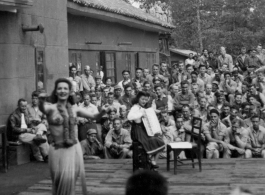 Celebrities (including here Mary Landa dancing, and apparently Ruth Dennis playing instrument) perform on an outdoor stage set up at the "Last Resort" at Yangkai, Yunnan province, during WWII. Notice both Americans and Chinese in the audience for this USO event.