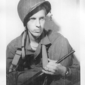 Sgt. Vern P. Martin posing with helmet and carbine in China during WWII.
