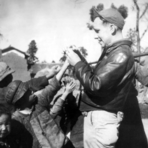 Sgt. Robert H. Zolbe, with kids in China (almost certainly Yunnan Province), handing out candy. Zolbe served in the 308th Bombardment Group, 425th Squadron on a B-24 bomber.