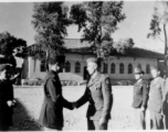 GIs shake hands during citation ceremony in China during WWII.  Image provided by Emery and Beth Vrana.