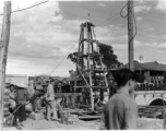 Local people in Yunnan, China: A construction site, using a small wooden derrick to drive in piles or dig a well. During WWII.