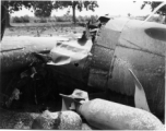 Wrecked B-25 Mitchell bomber on the ground in the CBI. The wreck was apparently at an air base, and probably on take-off, as the craft is sprayed with fire-retardant foam, and bombs are scattered about the wreck site. During WWII.