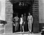 American soldier, KMT solder, and KMT civilians at rally pose for portrait shot. In the suit in the center should be An Zefa (安则法), a highly educated official who had a number of roles in Yunnan during WWII.  These men stand in the gate of an elite residence in Yunnan province, which has been appropriated by Nationalist 5th Corps forces for military purposes--the white paper posted on the door post says the residence is temporary housing for assistant staff for officers, and HQ for an armored unit. The resi