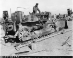 Shown working on D7 Bulldozer at Tengchong BRE Camp, after it was brought over the Hump, are L to R, Pvt. William Guthrie, and T/4 Curtiss R. Greenwood.  Photo by T/Sgt. Greenberg.  Passed by censor Emanuel Goldberg.