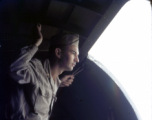 A flyer gazes out of the open cargo door of a cargo aircraft (a C-47 or C-46) during WWII.