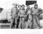 Members of Poston crew pose jovially with B-24 bomber of the 9th Bombardment Squadron, 7th Bombardment Group, 10th Air Force, on concrete of air base during WWII.
