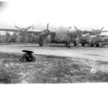 American flyers pose before B-24 "Doodlebug" In SW China as the bomber is being refueled.  During WWII.