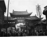 Street scene in Kunming, China, and arch with "天开云瑞"坊. During WWII.