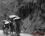 Bearers carry people in sedan chairs up mountain in northern China during WWII.