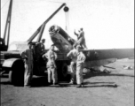 12th Air Service Group mechanics salvage a P-51 fighter in Guangxi, China, during WWII, cranking the aircraft up onto a flatbed truck.