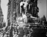 GIs examine Burmese Buddha statue in destroyed temple. During WWII.