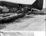 Bundles of food and ammunition being loaded aboard a C-47 of the 14th Air Force Transport Unit. They will be kicked out to Chinese troops cut off from ground supply in eastern China.