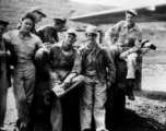 "Mission time." American flyers prepare themselves for another mission during WWII. Note the parachutes at the ready on the ground.